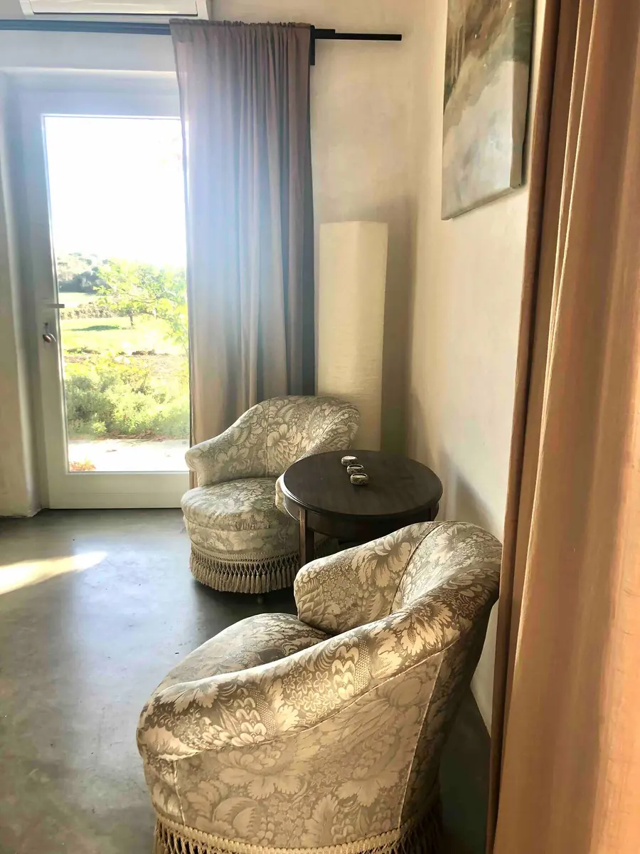 Two armchairs and a small table beside the window in Room 1, looking out over green fields