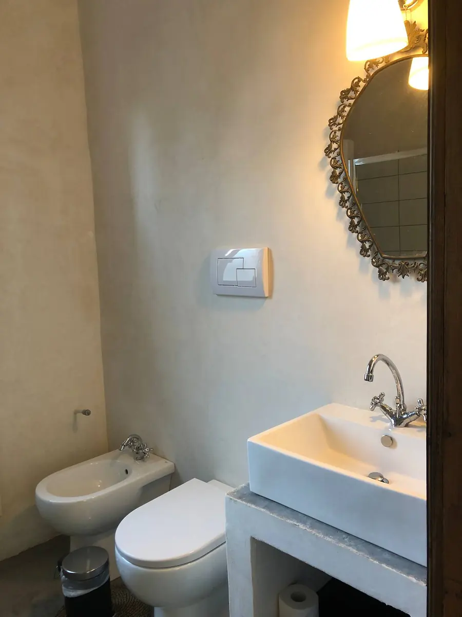 The bathroom for Room 2, with a gilt mirror, basin, toilet and bidet